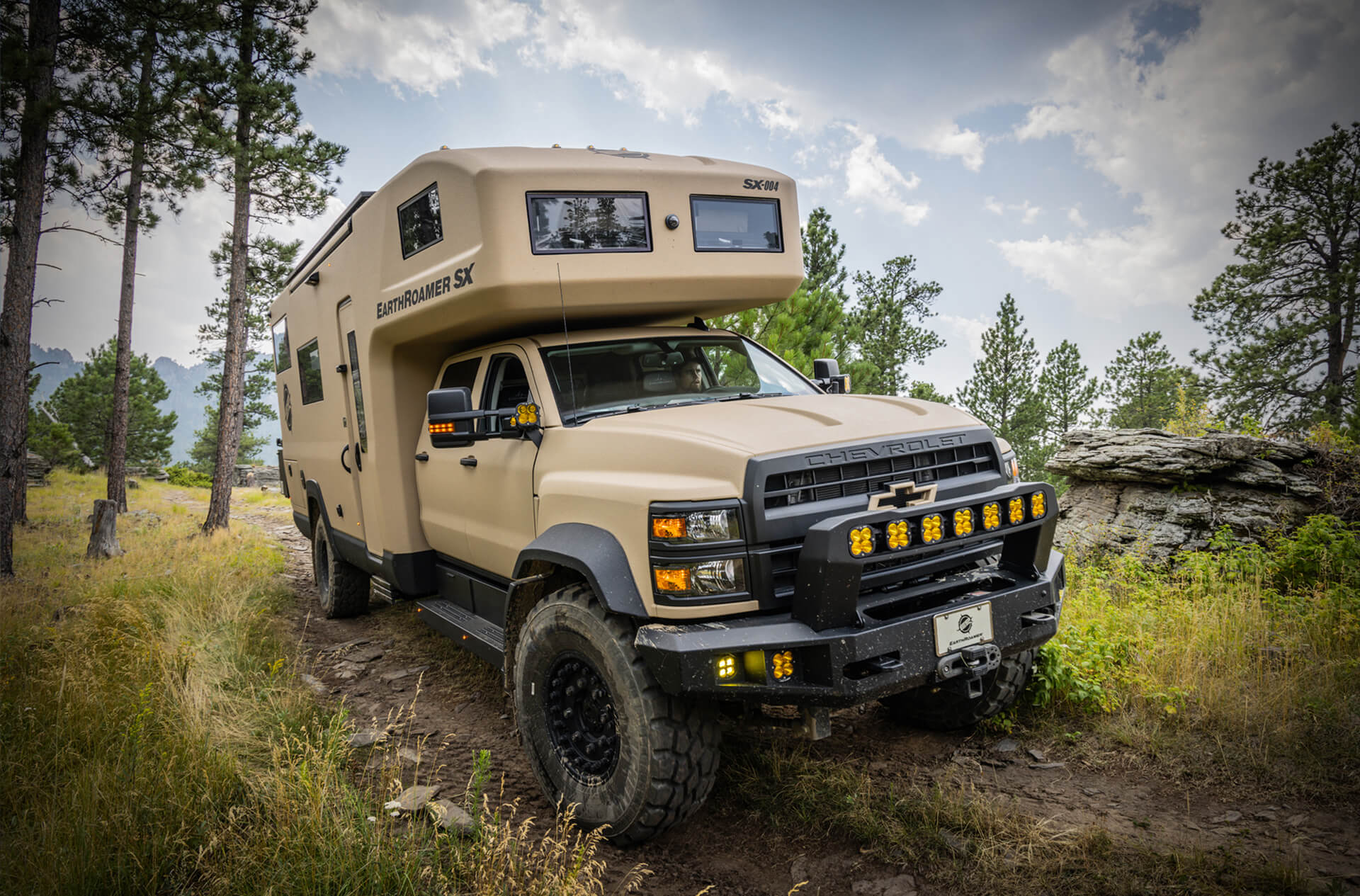 EarthRoamer SX expedition vehicle on rugged trail in the forest