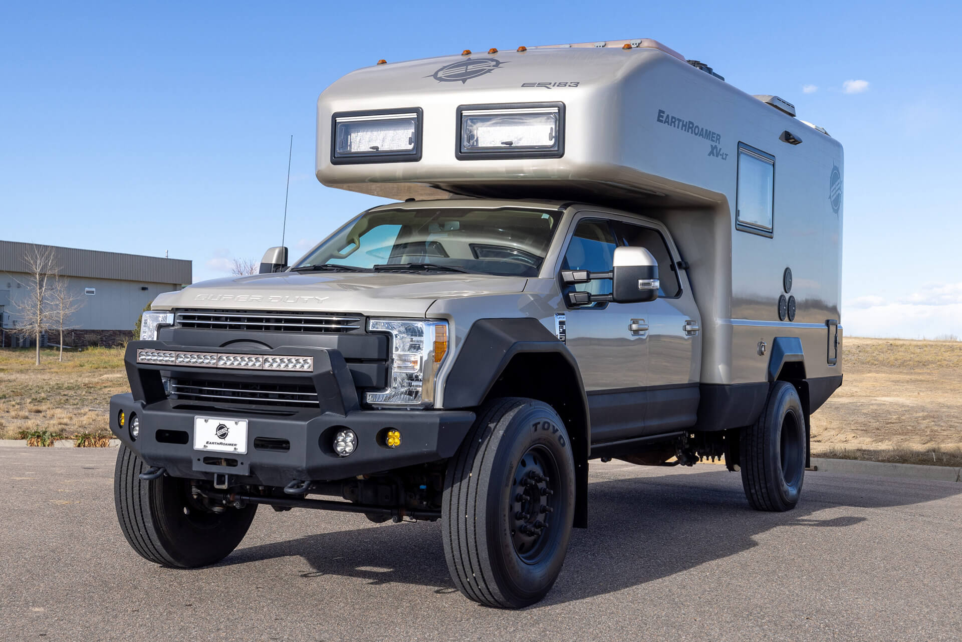 EarthRoamer luxury expedition vehicle interior featuring a modern wood-accented lounge and dining space.