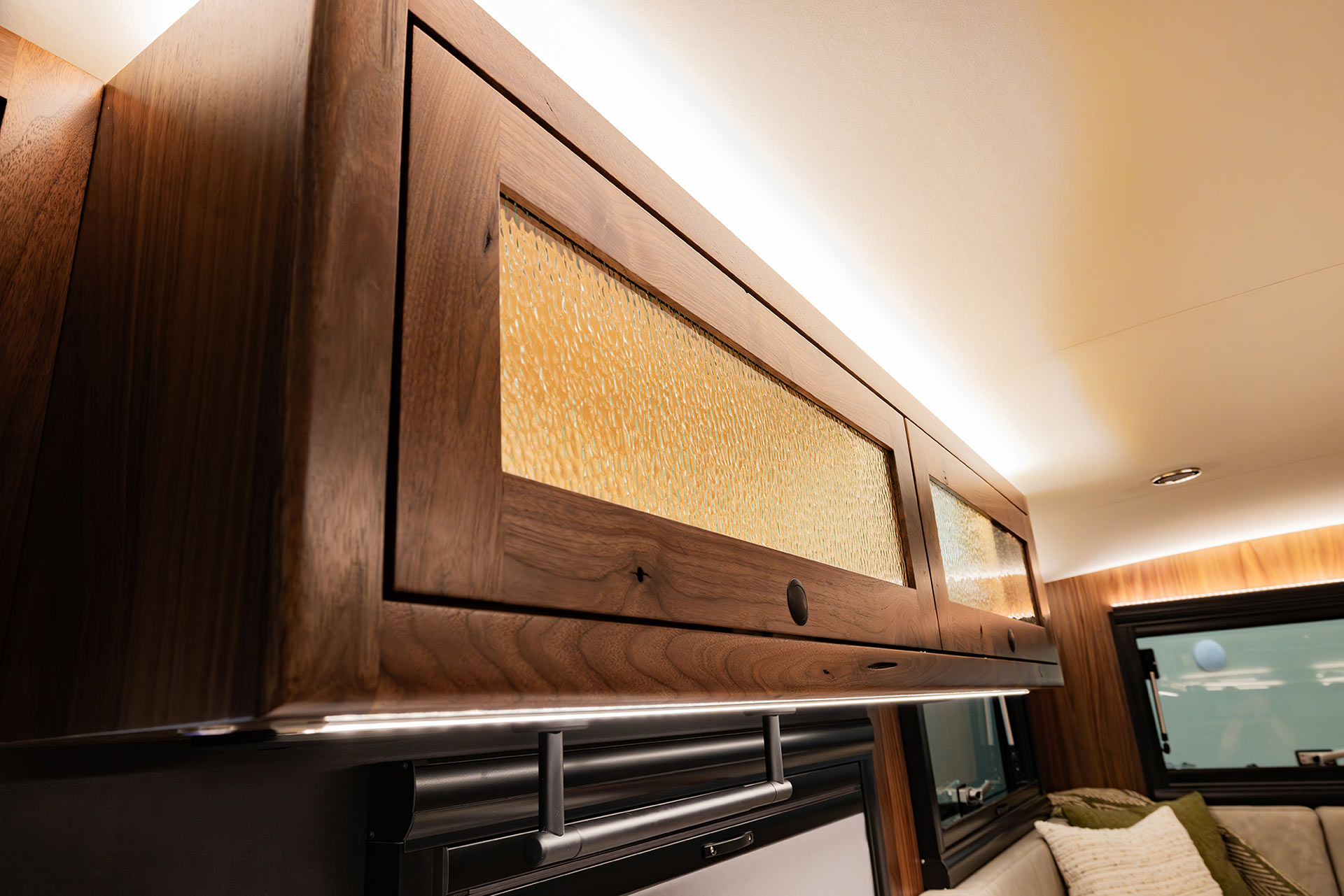EarthRoamer upper storage cabinet with organized dishes and glasses in secure slots.