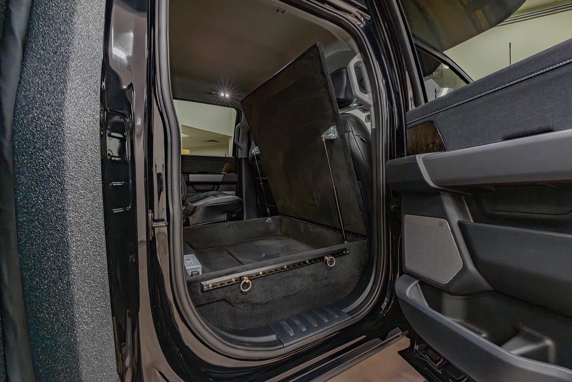 EarthRoamer rear truck cabin with lifted seat storage compartment revealed.