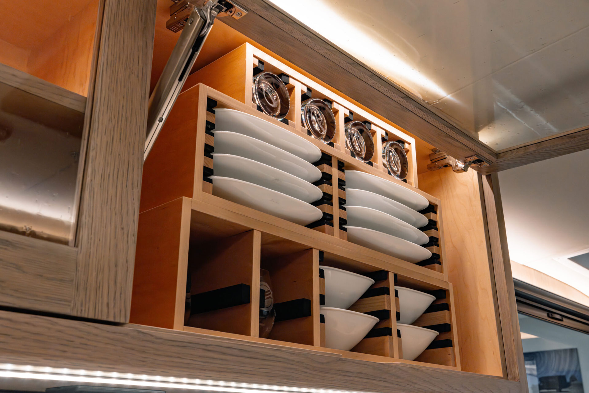 Overhead cabinets in EarthRoamer SX kitchen with neatly organized plates and bowls