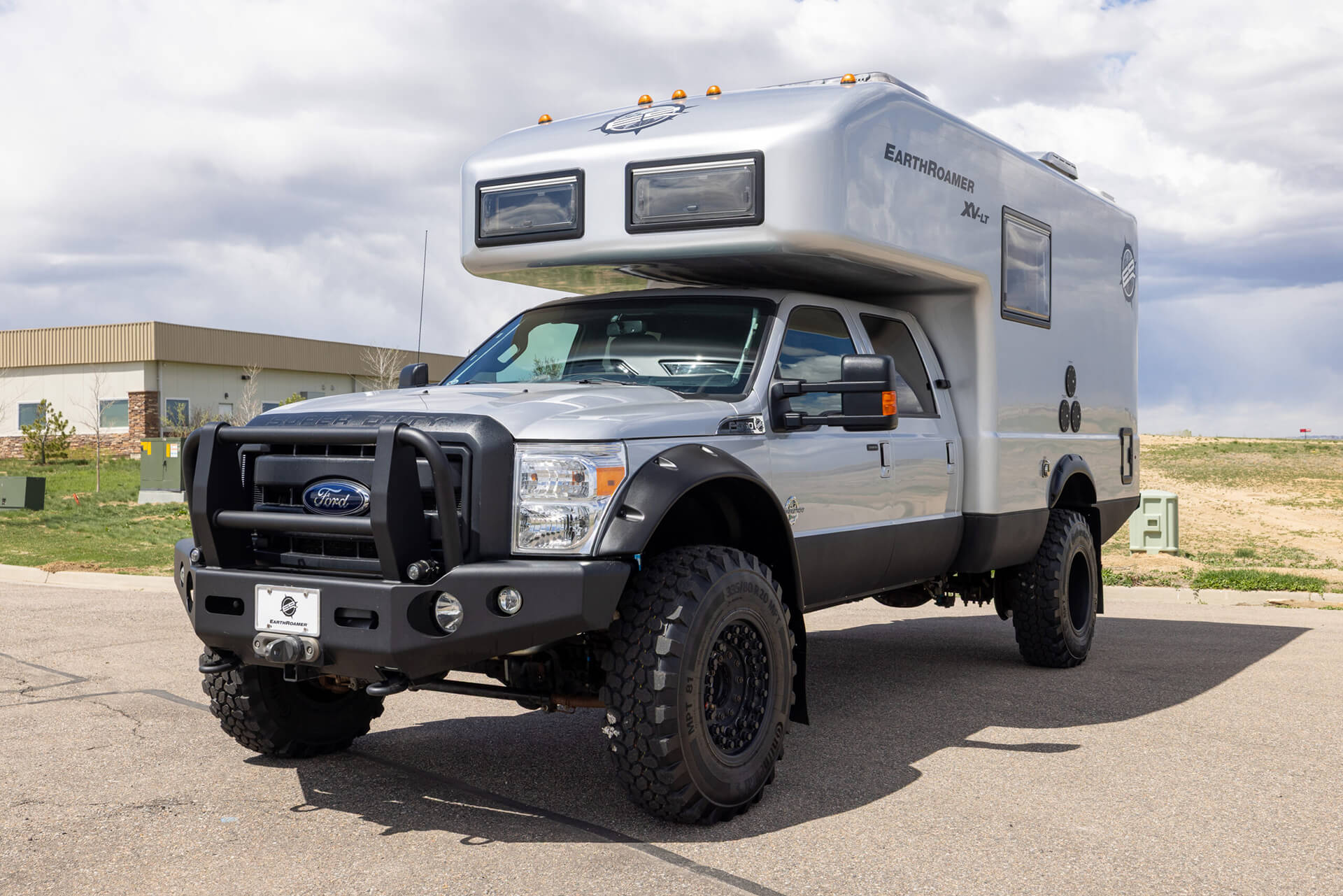 EarthRoamer camper interior with premium wooden cabinetry, stainless steel appliances, and cozy seating area.