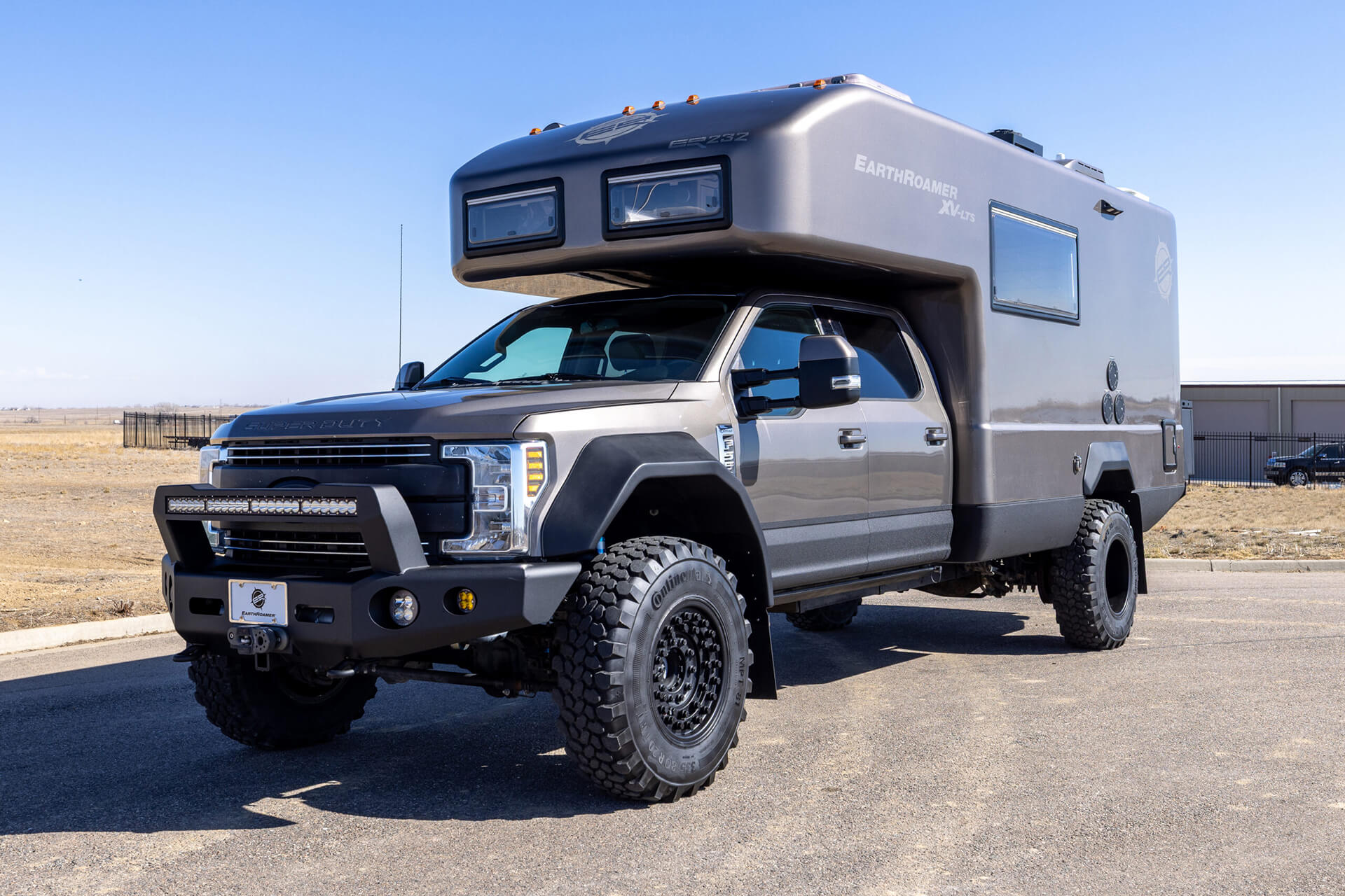 EarthRoamer camper interior with built-in kitchen, marble countertop, and sleek wooden cabinetry.